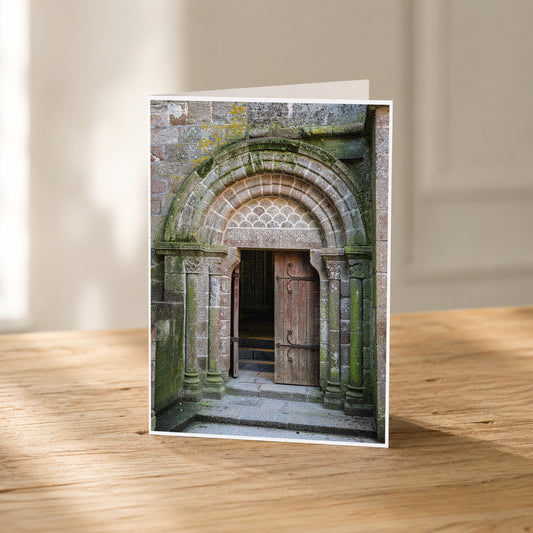 A wooden door with a stone archway, set in a mossy stone wall, is the focal point of the image.