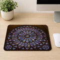 Notre-Dame Cathedral rose window stained glass mouse pad on a wood desk next to a mouse