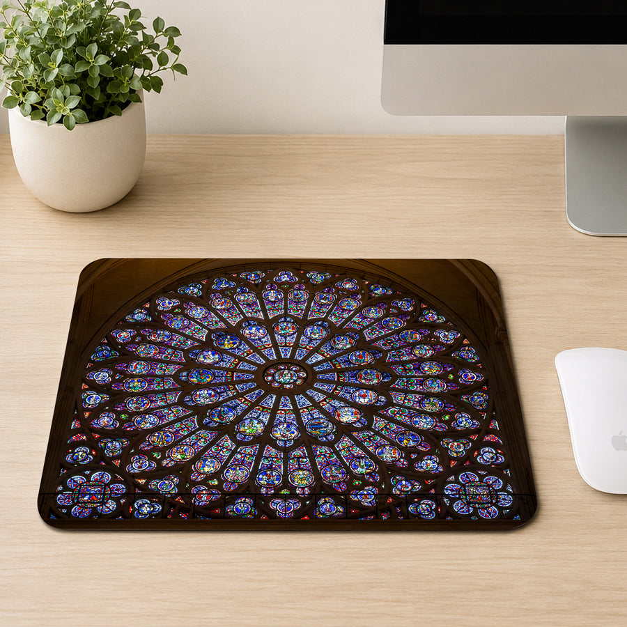 Notre-Dame Cathedral rose window stained glass mouse pad on a wood desk next to a mouse