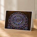 A framed photograph of a large, colorful stained glass window in a cathedral or church.