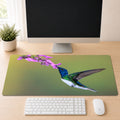 White-necked Jacobin hummingbird in flight feeding from purple flowers, shown as a desk mat design on a wood desk