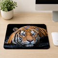Malayan tiger resting in dark water with intense eyes and wet whiskers, printed on a mouse pad