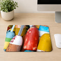 Stack of weathered red, yellow, and blue lobster buoys in close-up, printed on a mouse pad