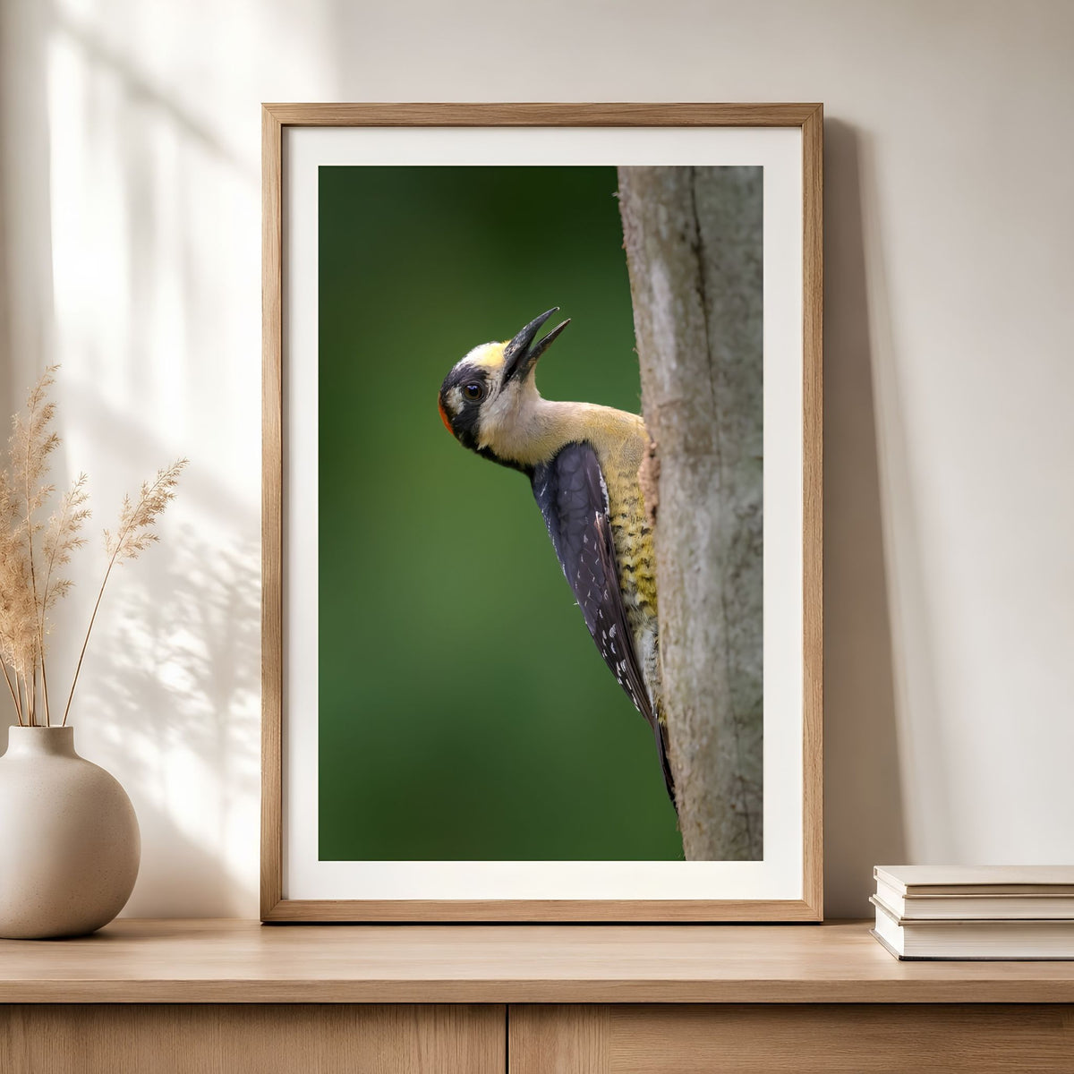 Framed artwork of a bird on a branch in a home setting