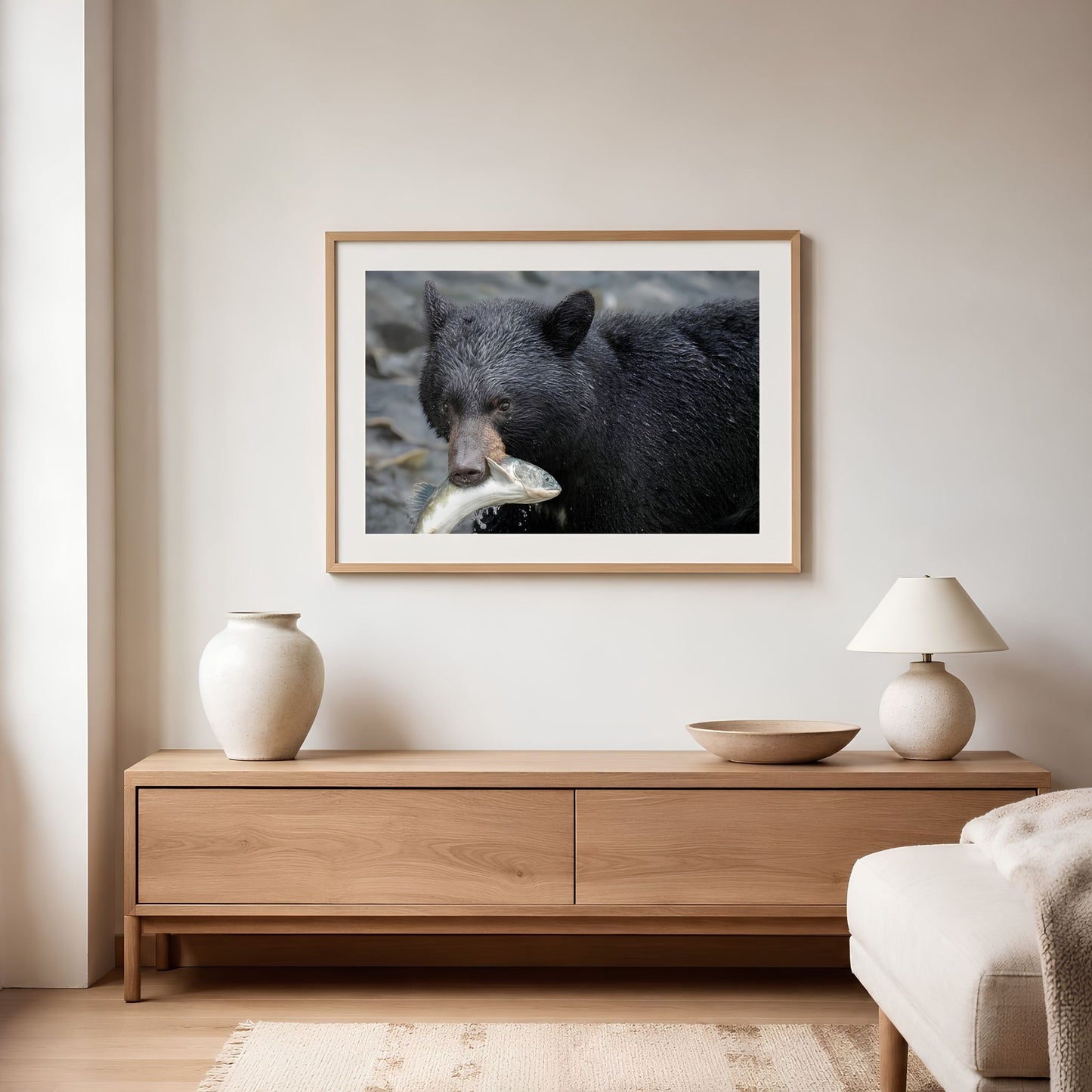Framed picture of a bear on a wall above a wooden cabinet in a living room.