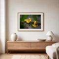 Framed artwork of a yellow snake on a branch above a wooden console table in a living room.