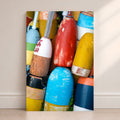 Colorful lobster buoys in red, yellow, blue, white, and orange stacked together with weathered paint and coastal texture