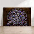 Notre-Dame rose window fine art photography print leaning against a white wall on a light wood floor.