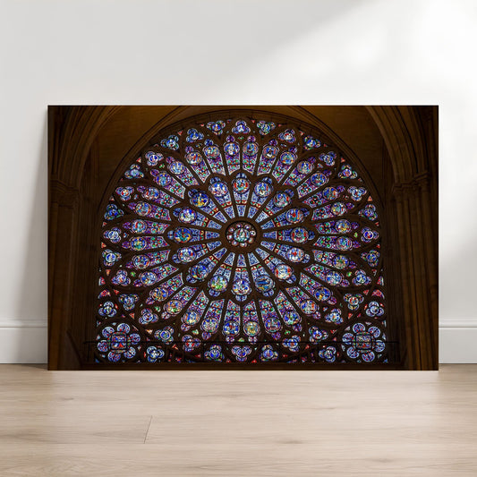 Notre-Dame rose window fine art photography print leaning against a white wall on a light wood floor.