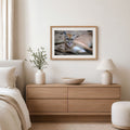 Framed picture of a cougar on a wall above a wooden dresser in a bedroom.