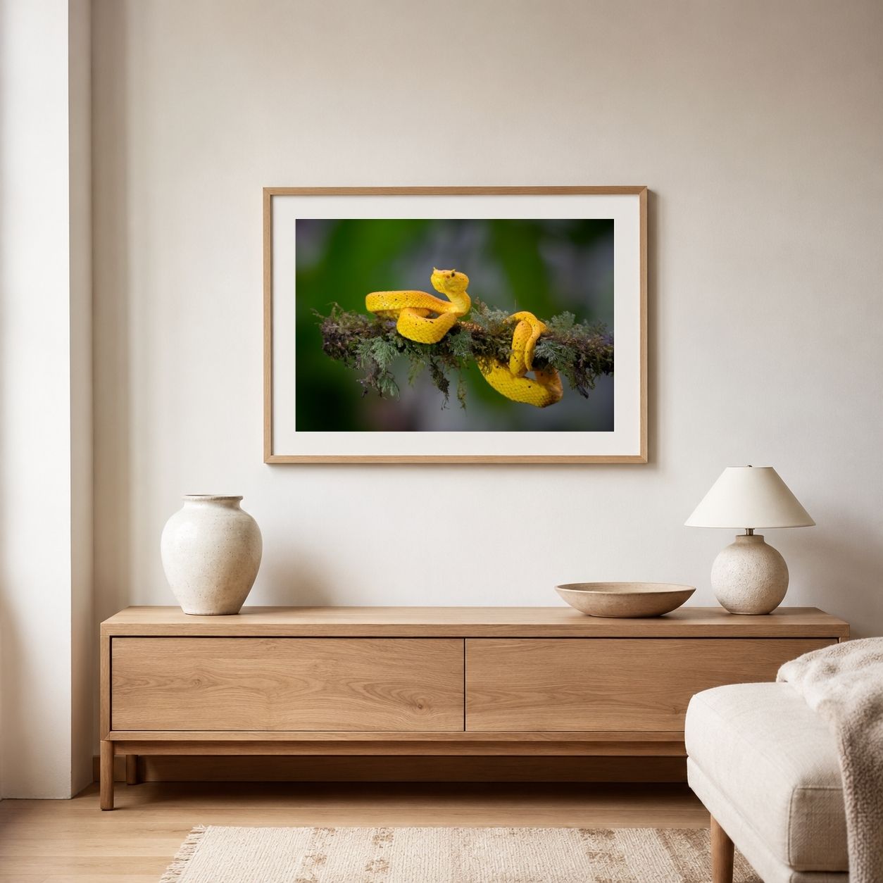Framed artwork of a yellow snake on a branch above a wooden console table in a living room.