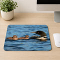 Adult Common Loon swimming with two fuzzy brown chicks on blue lake water, printed on a mouse pad