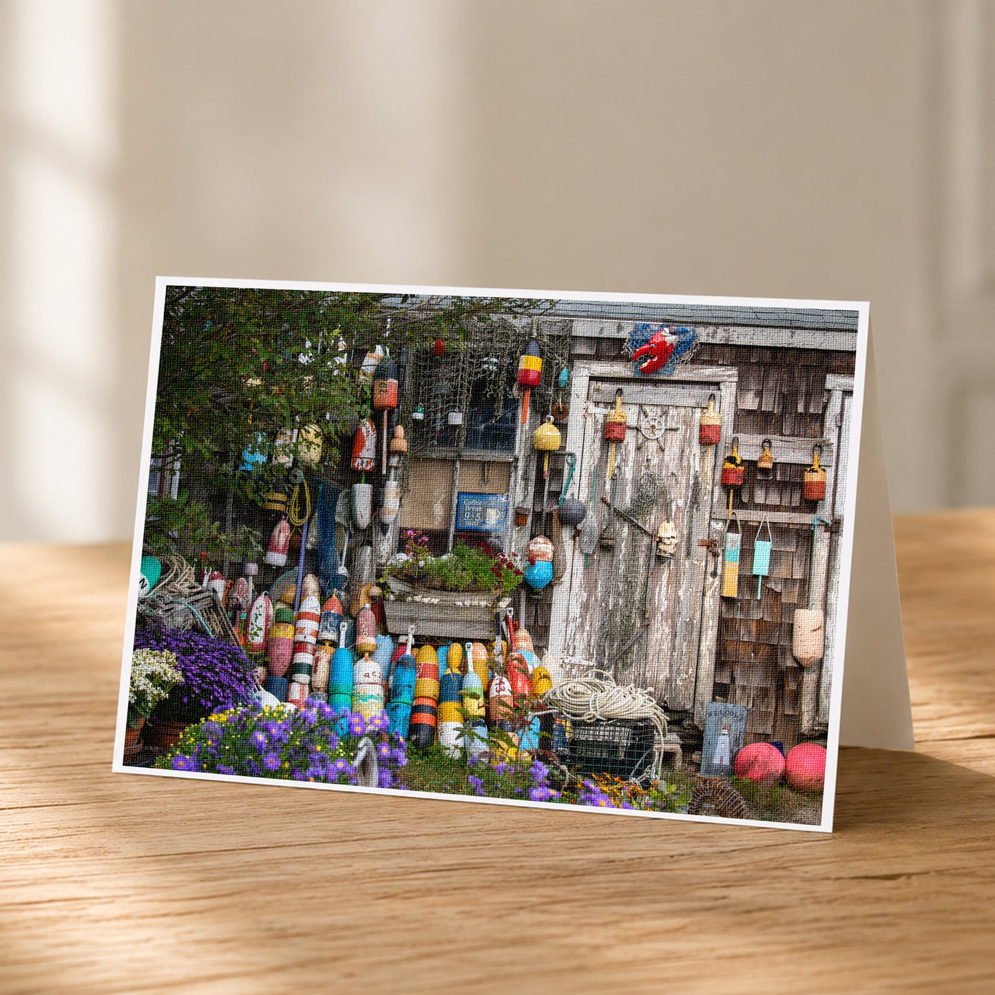 A wooden table displaying a vibrant collection of colorful buoys, potted plants, and other nautical items.