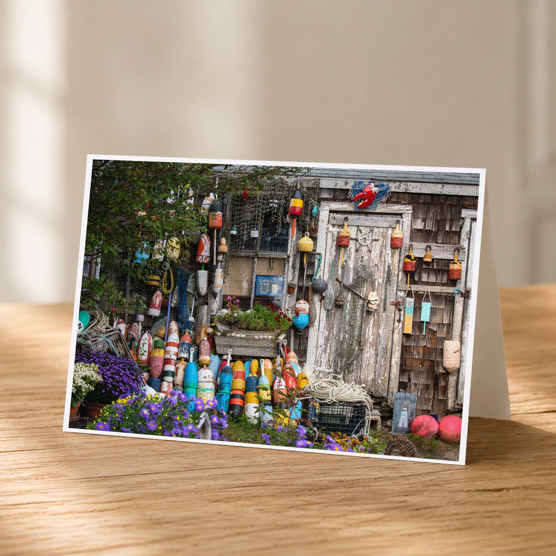 A wooden table displaying a vibrant collection of colorful buoys, potted plants, and other nautical items.