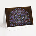 A large, colorful stained glass window with intricate patterns and designs, set within an arched structure.