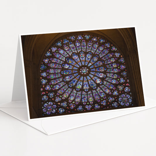 A large, colorful stained glass window with intricate patterns and designs, set within an arched structure.