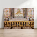 an ornate, gilded bed with floral patterns and a white headboard, situated in a room with a white wall and wooden floor.