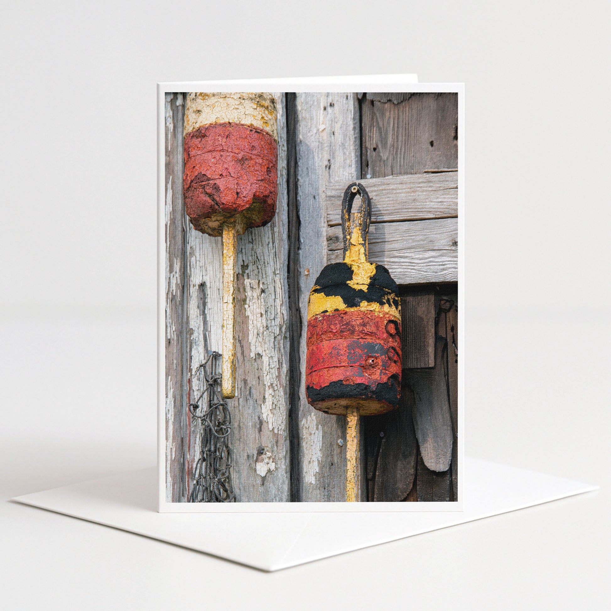 two rusty buoys hanging on a weathered wooden wall.