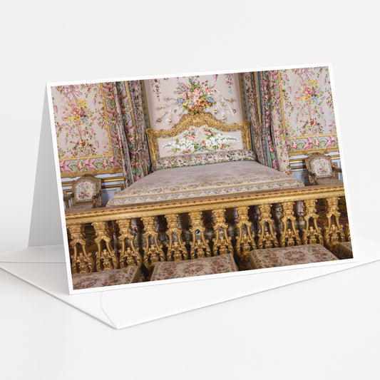 an ornate, gilded bed with intricate floral patterns and gold accents, set against a backdrop of a wall with a floral tapestry.
