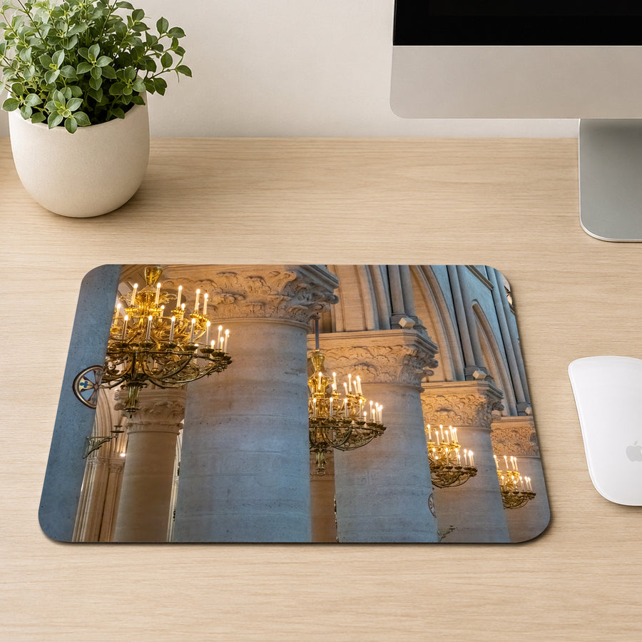 Row of gold candlelit chandeliers between Gothic stone columns inside Notre-Dame Cathedral, printed on a mouse pad